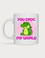 Cute mug - cartoon crocodile waving on a pink circle with the text You Croc My World