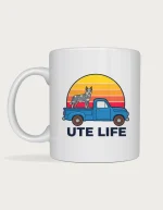 Ute life mug: Cartoon blue ute with a blue heeler cattle dog standing on the tray in front of a striped sunset, above the words Ute Life