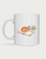 Book lover mug with a watercolour ginger cat curled up asleep on an open book next to a cup of tea and a stack of books, on a white ceramic mug
