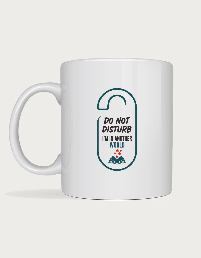 Funny reading mug with a door hanger sign design reading Do Not Disturb, I'm In Another World with a small open book, on a white ceramic mug