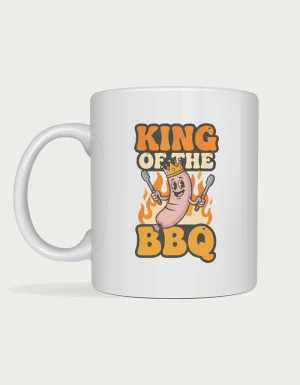 Dad mug - crowned cartoon sausage holding tongs with King of the BBQ lettering printed on a white ceramic mug