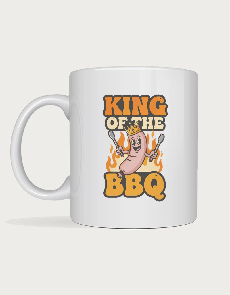 Dad mug - crowned cartoon sausage holding tongs with King of the BBQ lettering printed on a white ceramic mug