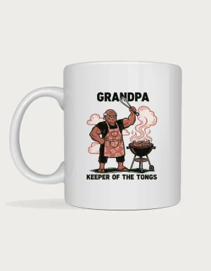 Funny grandpa gifts - linocut grandpa holding BBQ tongs beside a barbecue with sausages, Keeper of the Tongs, on a white ceramic mug