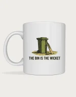 Backyard cricket mug: Linocut illustration of a wheelie bin used as cricket stumps on a dry lawn, with a bat and tennis ball, above the words The Bin Is the Wicket