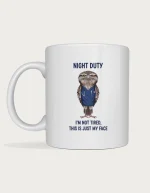 Tawny frogmouth mug with a grumpy frogmouth in navy nurse scrubs and the words Night Duty, I'm not tired, this is just my face
